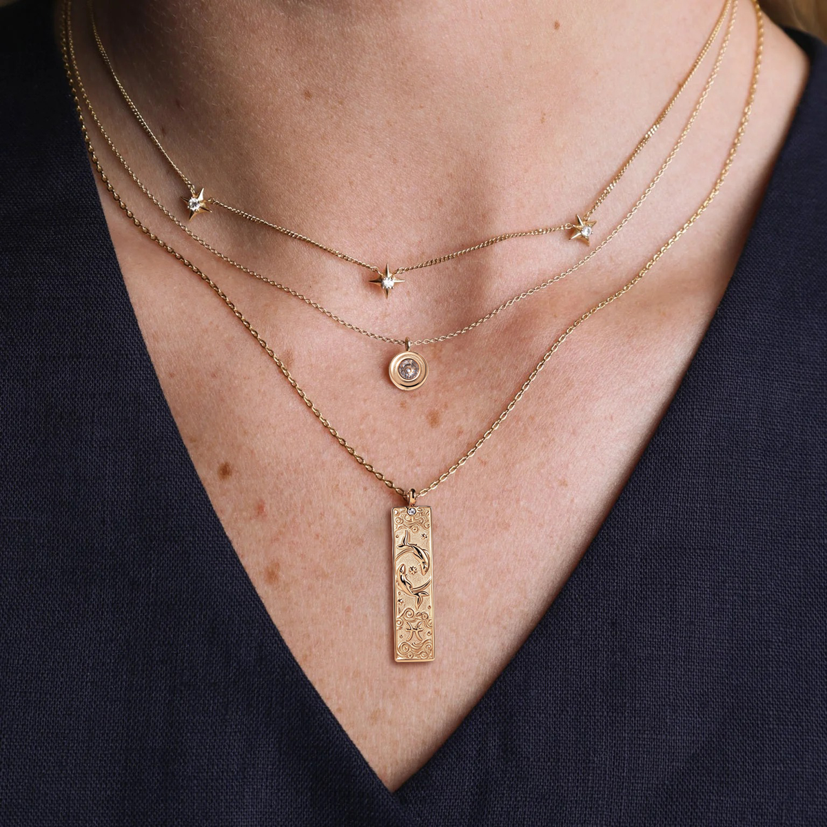 Gold constellation necklace on a warm white background